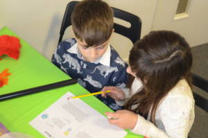 Children reading over the instructions for Letterbox Lab's kids science activities for their science subscription box
