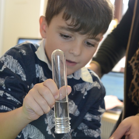 a boy doing a science trick with a test tube from letterbox lab